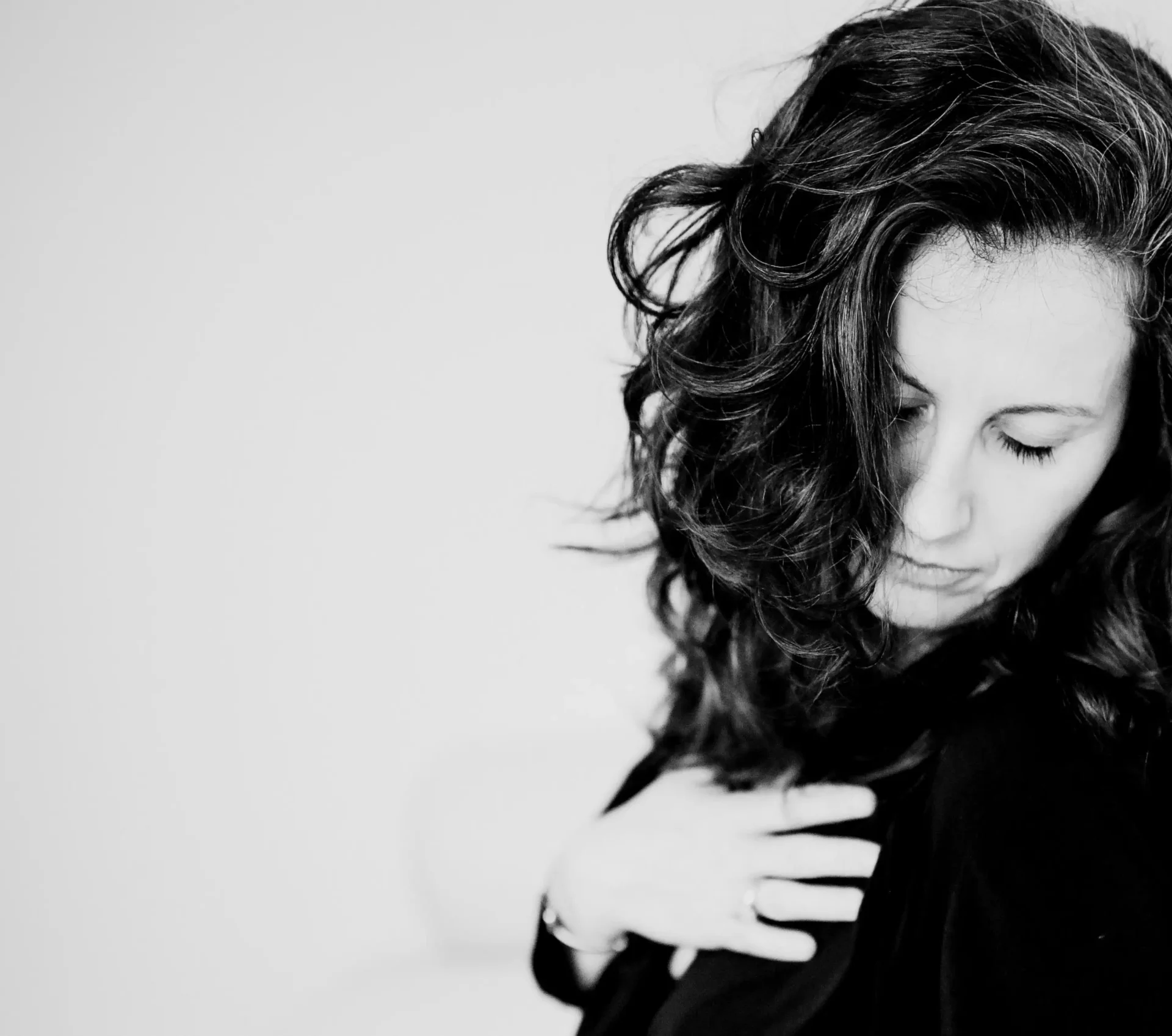 Jasmin mit geschlossenen Augen und Hand auf dem Herzen.