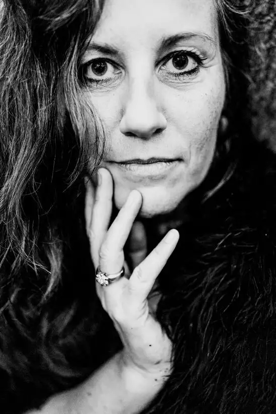 Jasmin im Portrait, mit wachen Blick und der Hand nachdenklich am Kinn.